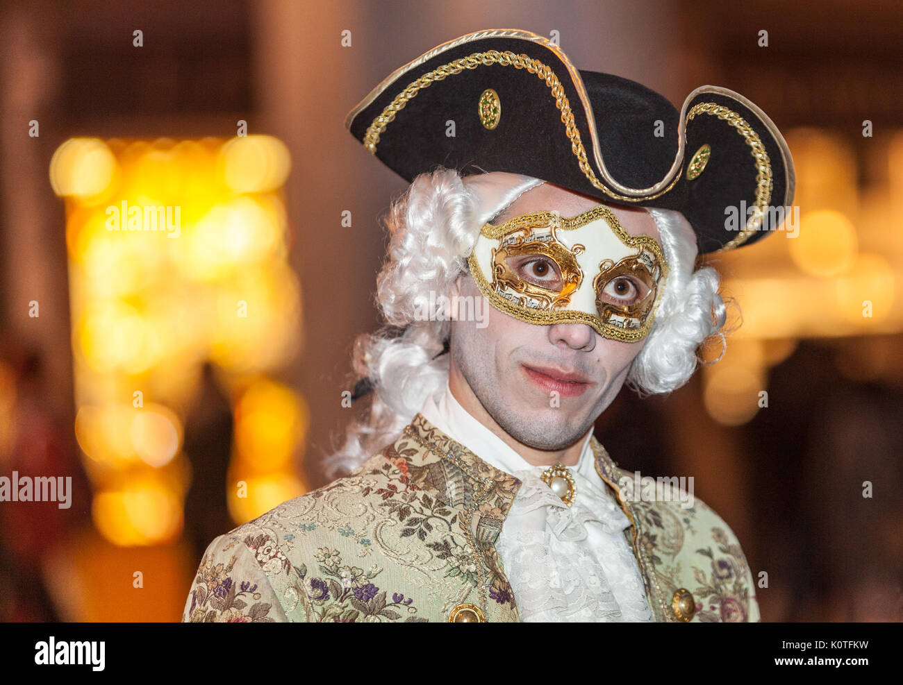 Venice, Italy- February 26th, 2011: Environmental portrait of a young man disguised in a marquis and wearing a traditional mask during the Venice Carn Stock Photo