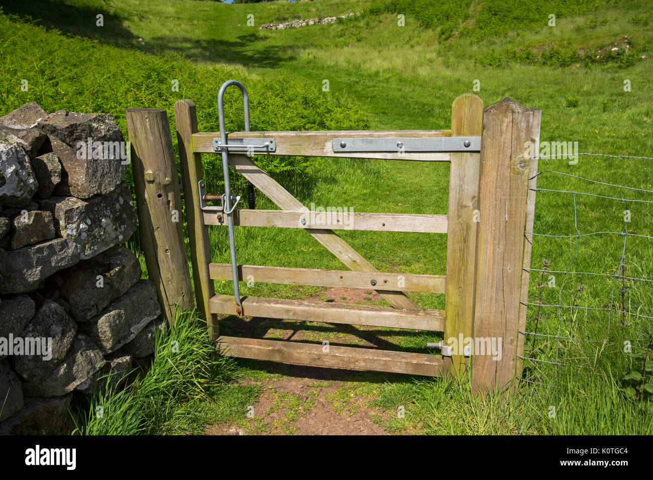 Wooden gate with automatic closing mechism on British walking track / public footpath Stock Photo