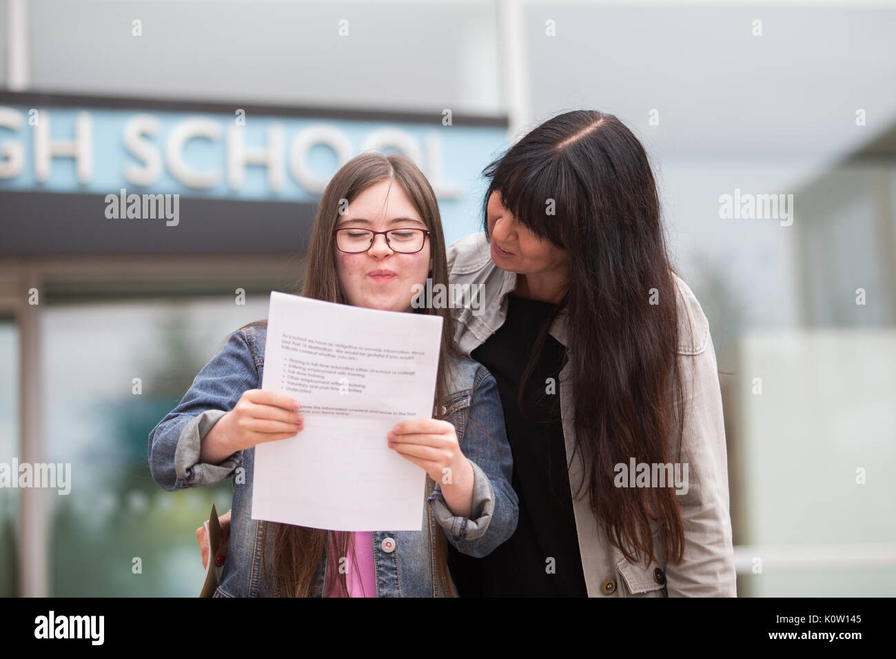Young school leaver who has Down's Sysdrome opens her GCSE exam results outside her secondary school UK Stock Photo