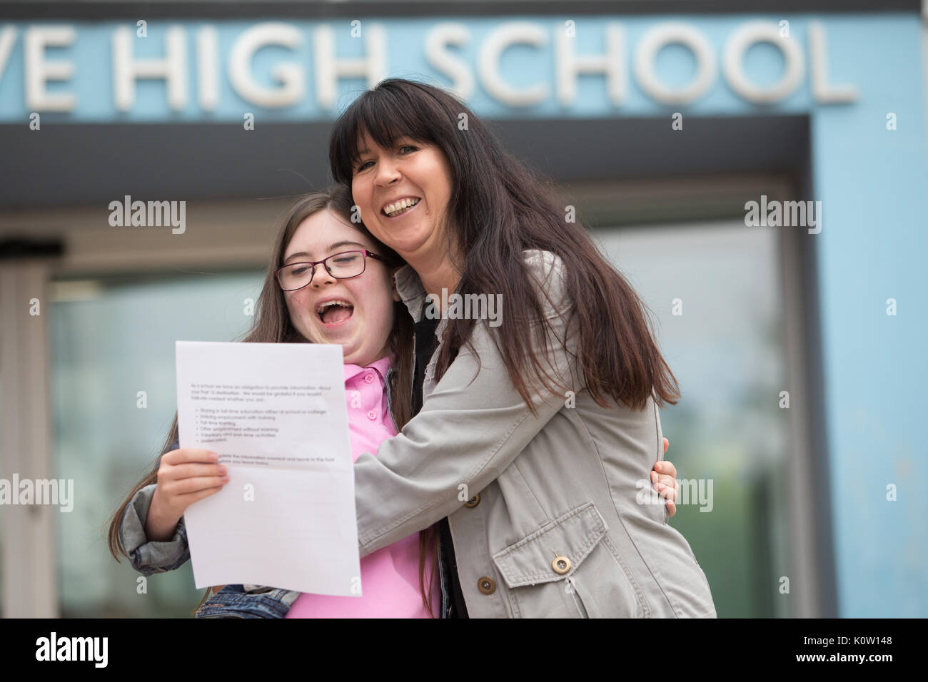 Young school leaver who has Down's Sysdrome opens her GCSE exam results outside her secondary school UK Stock Photo