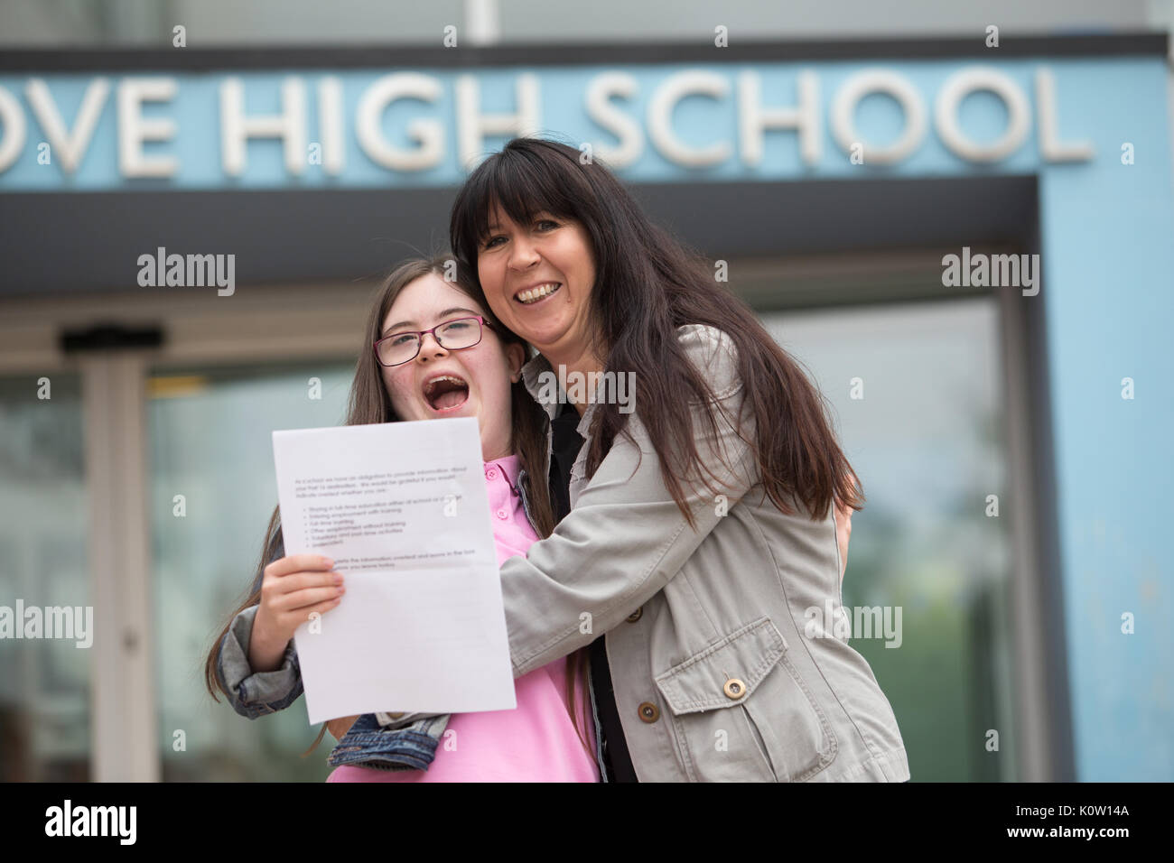 Young school leaver who has Down's Sysdrome opens her GCSE exam results outside her secondary school UK Stock Photo