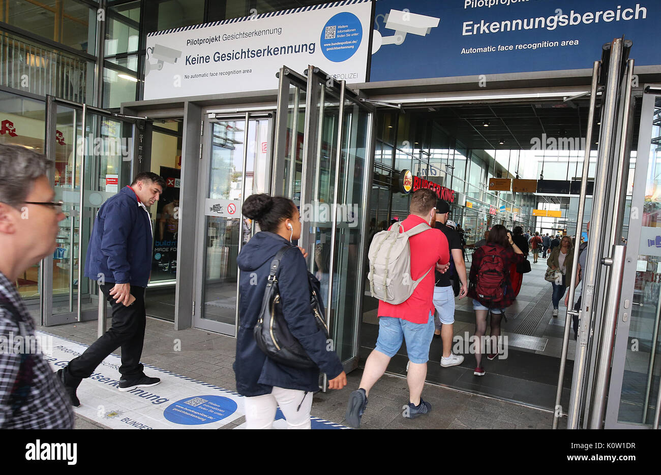 Travelers using an entrance marked with the text "face recognition ...