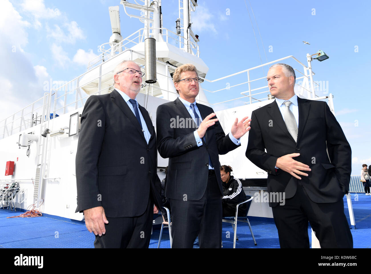 Denmark. 25th August, 2017. The Economy Minister of the state of Schleswig-Holstein, Bernd Buchholz (C), speaking with Senior Captain Johannes Wasmuth (L) and the head of the Scandline, Soren Paulsgaard, aboard the ferry 'Deutschland' traveling between Puttgarden, Germany and Rødbyhavn, Denmark, 25 August 2017. Buchholz had previously met with his Danish counterparts for talks on the Fehmarnbelt tunnel. Photo: Carsten Rehder/dpa/Alamy Live News Stock Photo