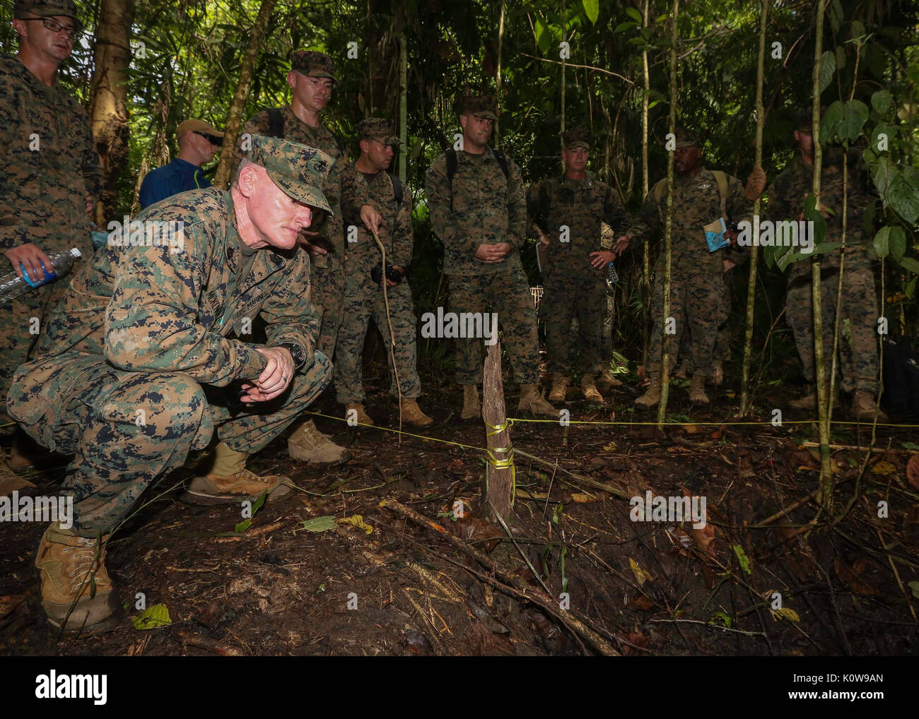 U.S. Marine Corps Sgt. Maj. Paul McKenna, force sergeant major of U.S. Marine Corps Forces, Pacific, crouches for a closer look Aug. 8, 2017, at the fighting position Gunnery Sgt. John Basilone held on Bloody Ridge, Guadalcanal, Solomon Islands. Basilone received the Medal of Honor for his actions during the Oct. 24 & 25, 1942 battle there.  Marines with 1st Marine Division and MARFORPAC learned about the small unit leadership exhibited during the Battle of Guadalcanal Aug. 7, 1942 to Feb. 9, 1943. (U.S. Marine Corps photo by Sgt. Wesley Timm) Stock Photo