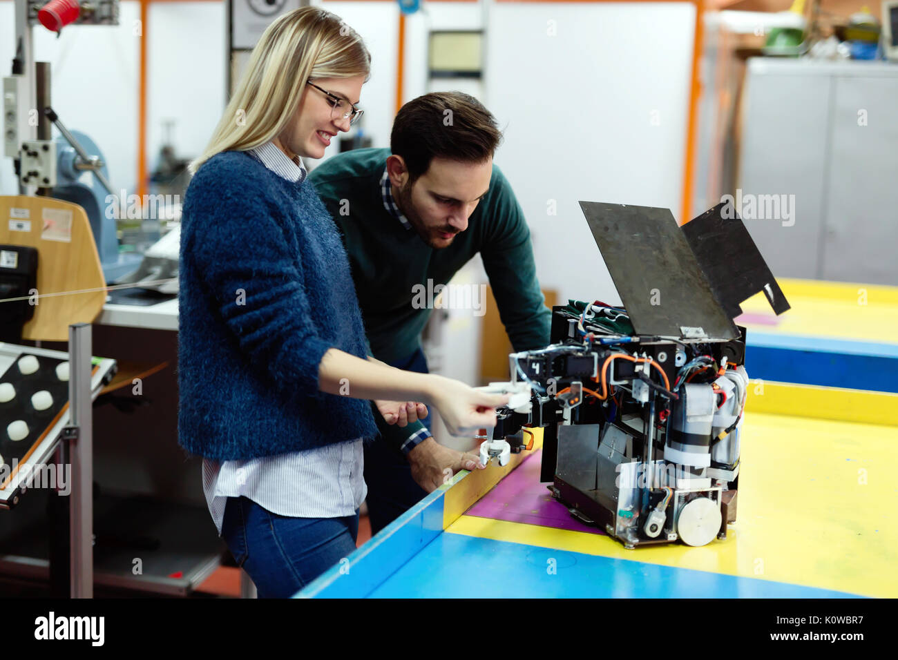 Young students of robotics preparing robot for testing Stock Photo