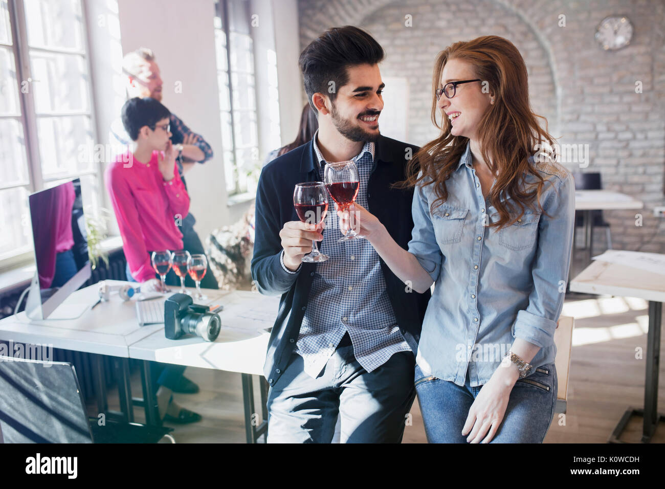 Happy young architects having break and drinking wine Stock Photo