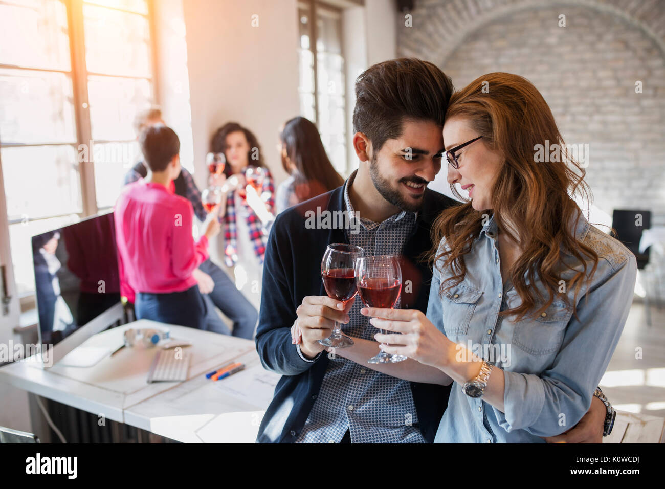 Happy young architects having break and drinking wine Stock Photo