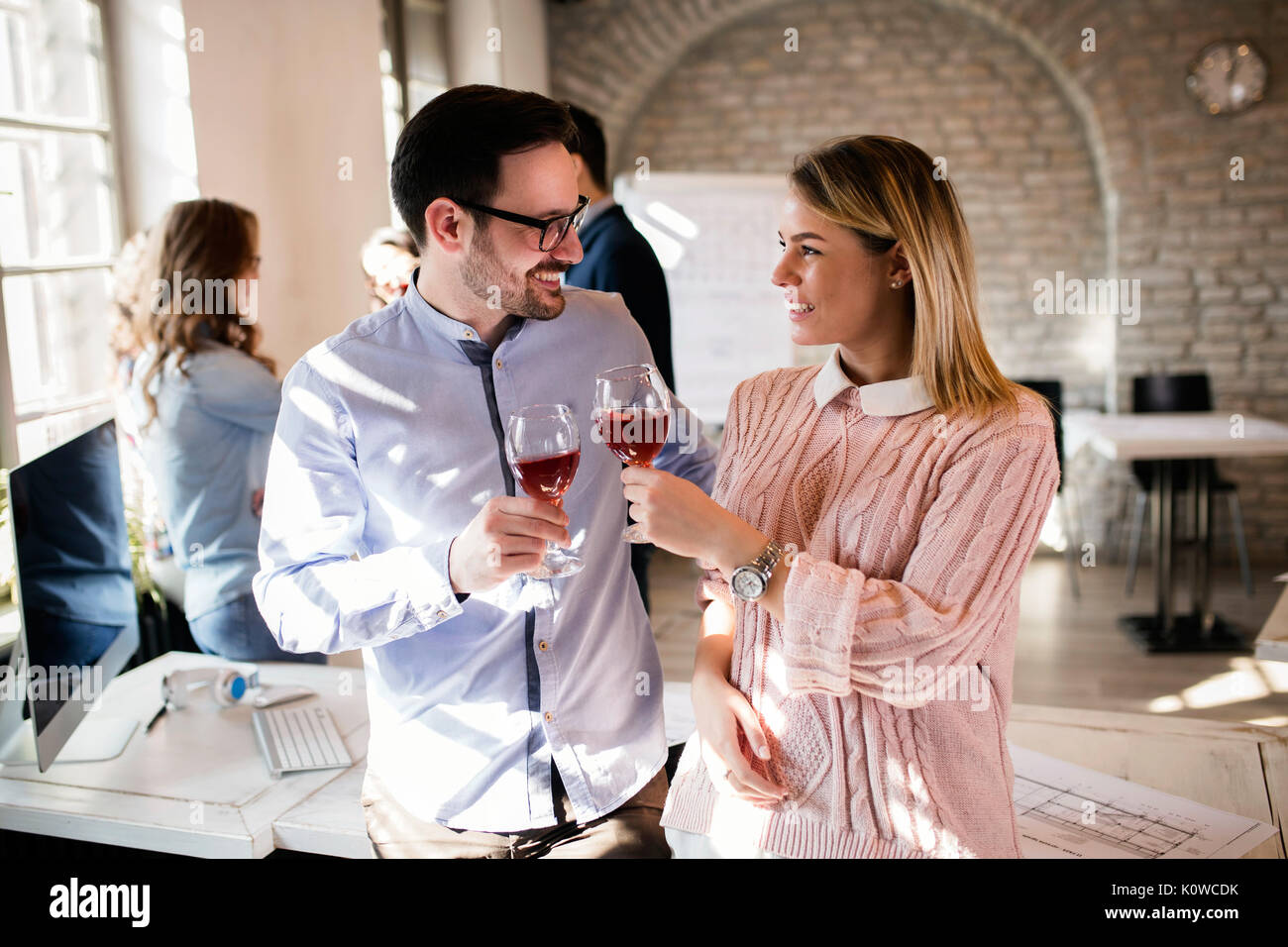 Happy young architects having break and drinking wine Stock Photo