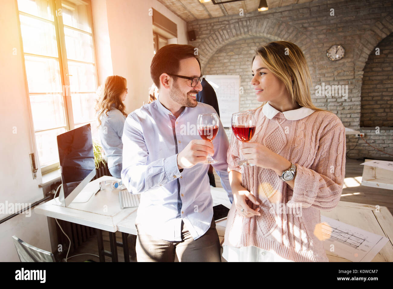 Happy young architects having break and drinking wine Stock Photo
