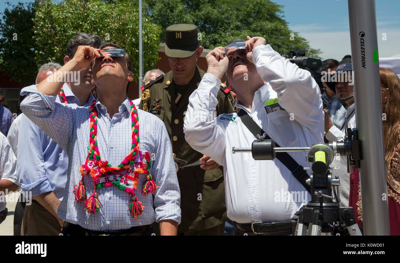 Mexican President Enrique Pena Nieto joins school children  observing a partial solar eclipse at an elementary school August 21, 2017 in Aquismon, Mexico. The total eclipse swept across a narrow portion of the contiguous United States from Oregon to South Carolina and a partial solar eclipse was visible across the entire North American continent along with parts of South America, Africa, and Europe. Stock Photo