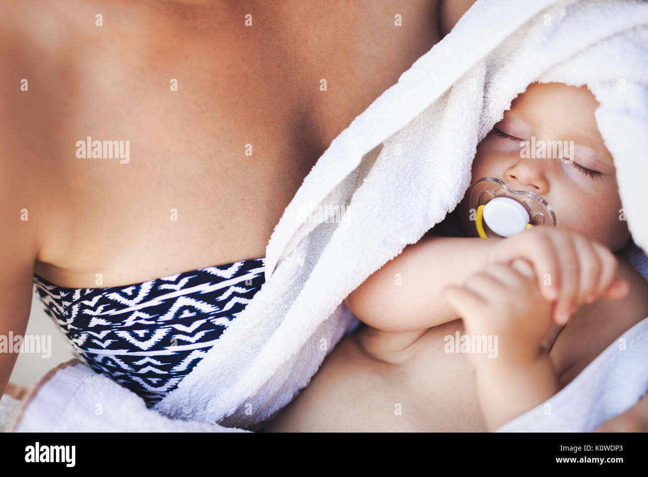 Young mother holding her sleeping newborn baby Stock Photo