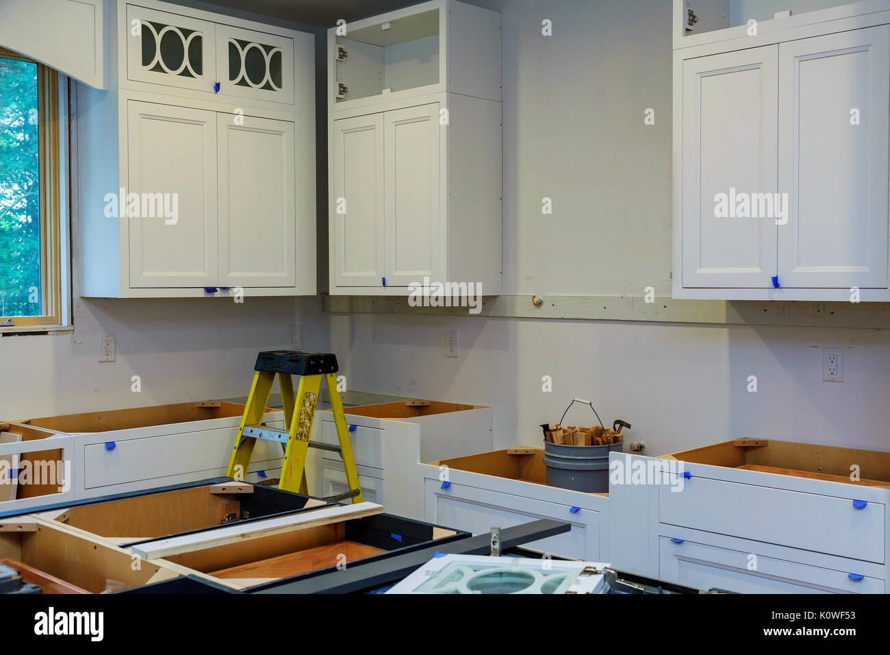 Custom kitchen cabinets in various stages of installation base for island in center Stock Photo