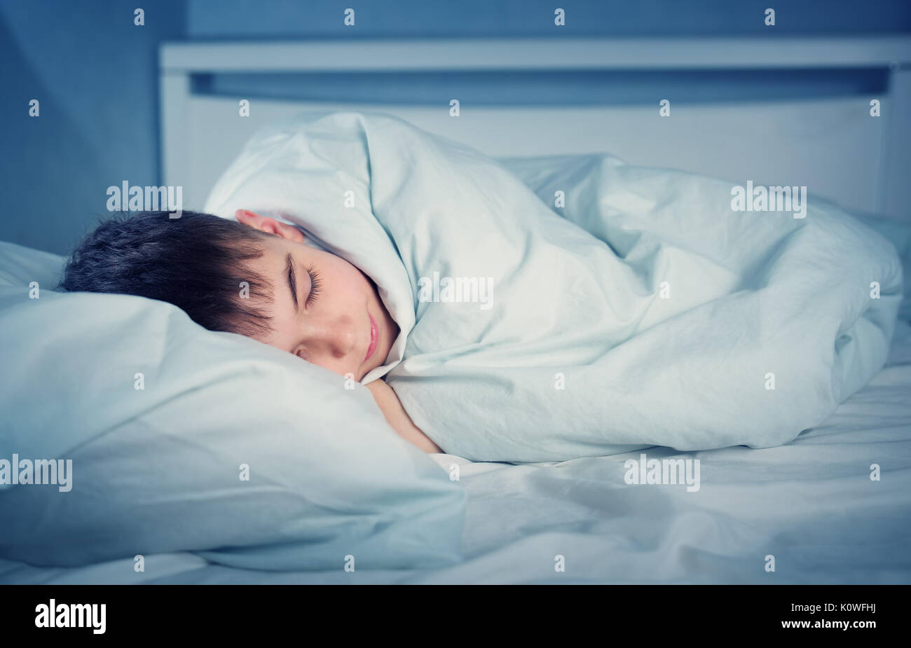 Boy sleeping in bed in pajamas Stock Photo Alamy