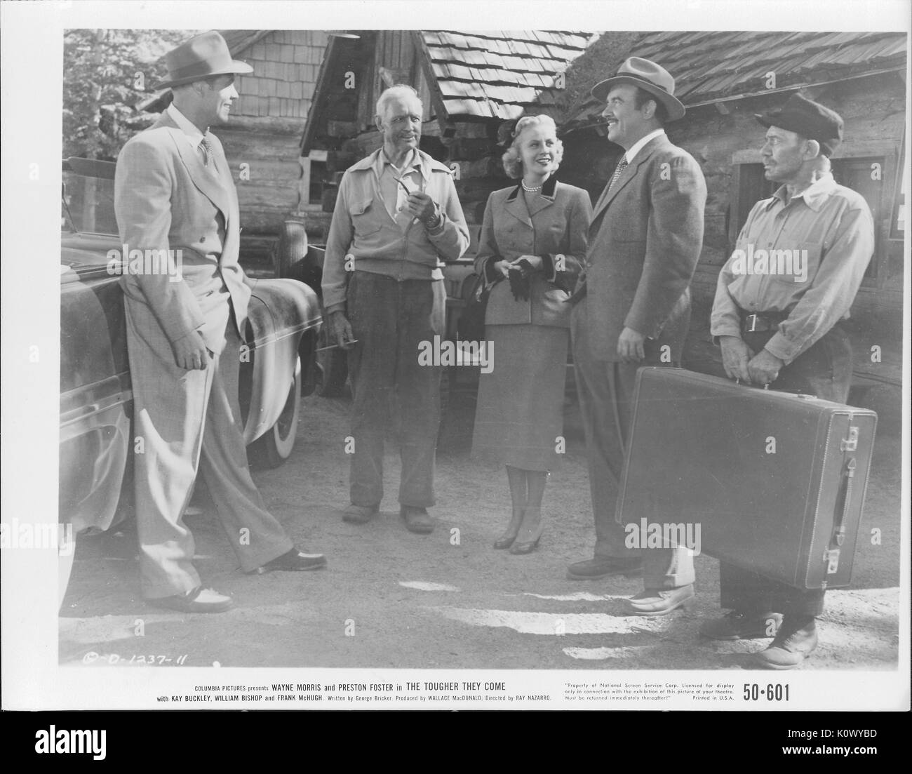 A movie still scene from 'The Tougher They Come' (1950 Columbia Pictures film), showing five adults standing outside a house, four men and a lady, amiably discussing matters of import, 1950. Stock Photo