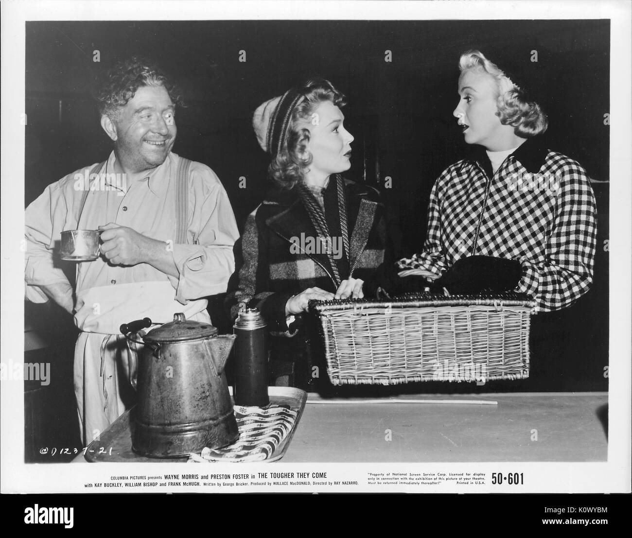 A movie still scene from 'The Tougher They Come' (1950 Columbia Pictures film), showing three adults, two women and a man, with the two ladies calmly arguing on something while holding on to a picnic basket, and the man beside the lady in the middle laughingly listening to them, 1950. Stock Photo