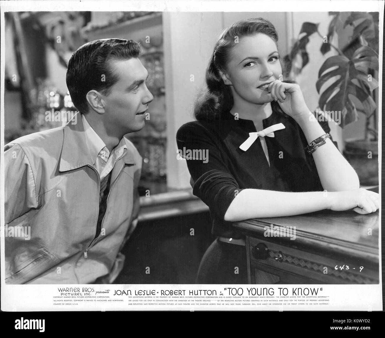 A movie still scene from 'Too Young To Know' (1945 American drama film), a Warner Bros Pictures production, showing a young man trying to amuse a young lady, 1945. Stock Photo