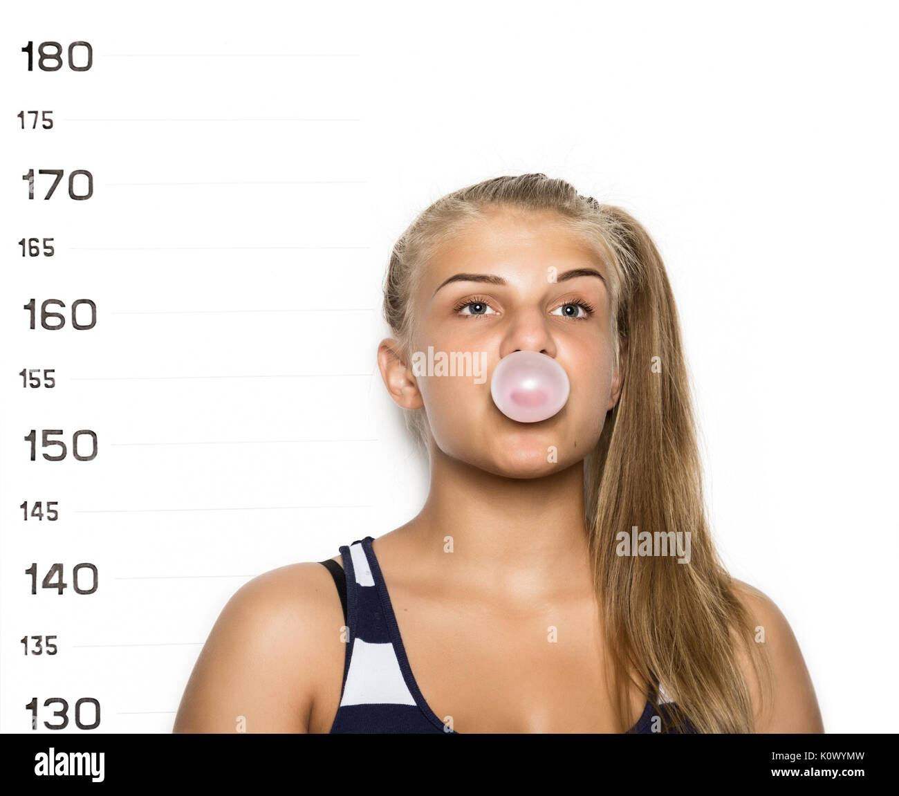 Young beautiful blonde woman chewing gum and blowing bubbles Criminal Mug Shots Stock Photo