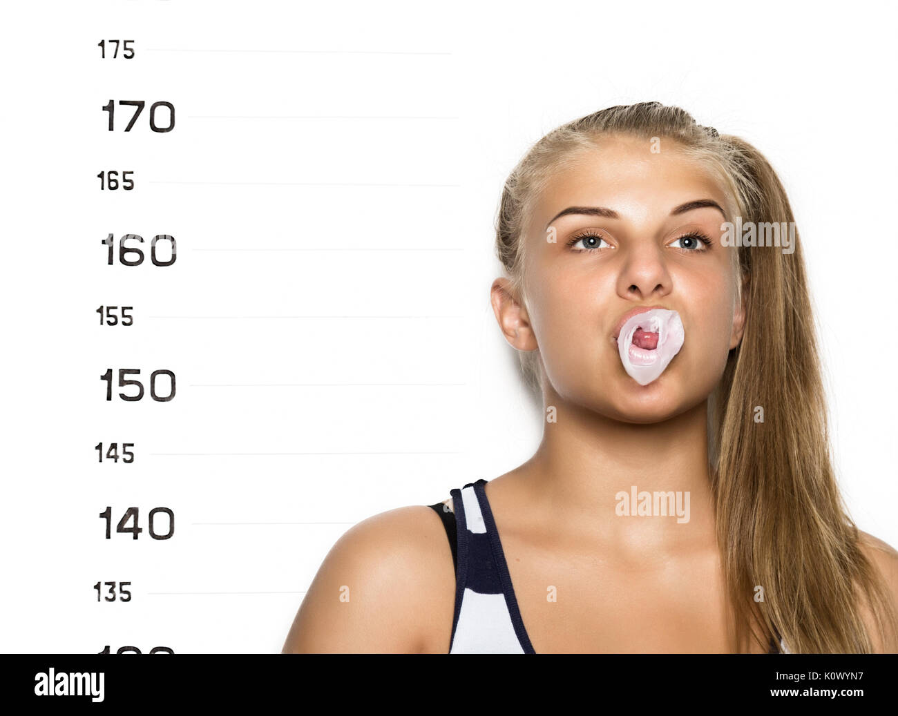 Young beautiful blonde woman chewing gum and blowing bubbles Criminal Mug Shots Stock Photo