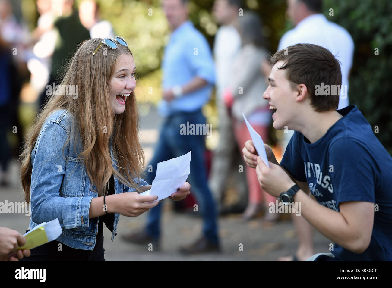 Ella Gant and Tom Moore celebrate after collecting their GCSE results at Norwich School. Stock Photo