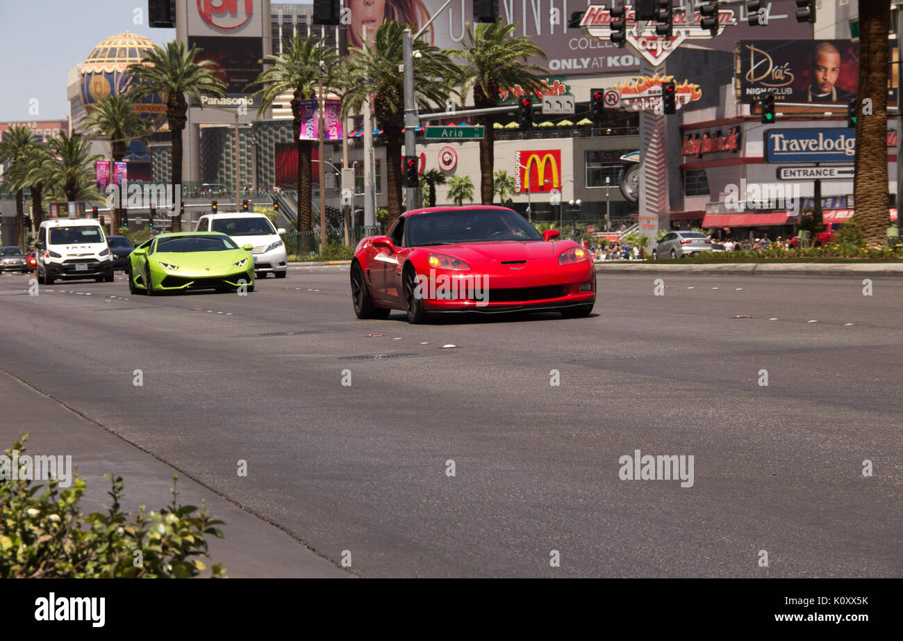 Sports cars driving on the main Las Vegas strip in front of the Planet  Hollywood casino Stock Photo - Alamy