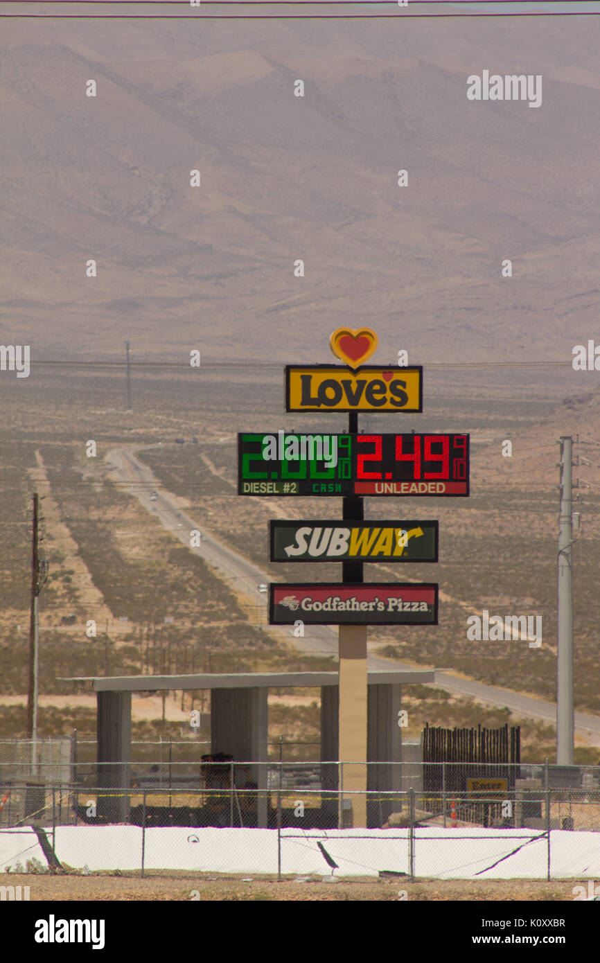 A fuel station sign in front of a long desert road near Las Vegas, Nevada Stock Photo