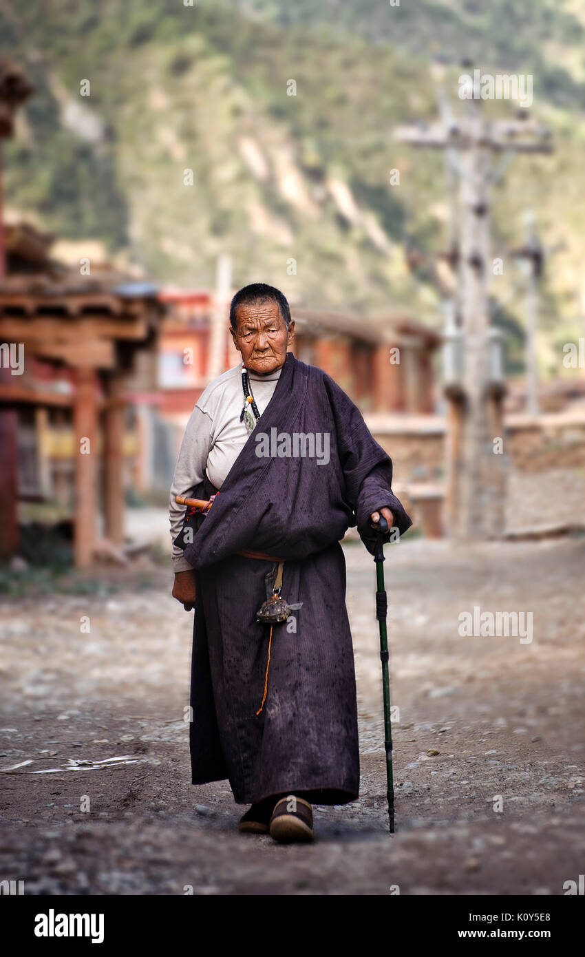 Old Tibetan woman deep into her prayers. Tibetan plateau Stock Photo