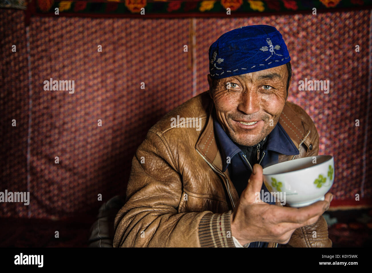 A green-eyed Uighur man resting and having lunch at noon in Remote Xinjiang Stock Photo