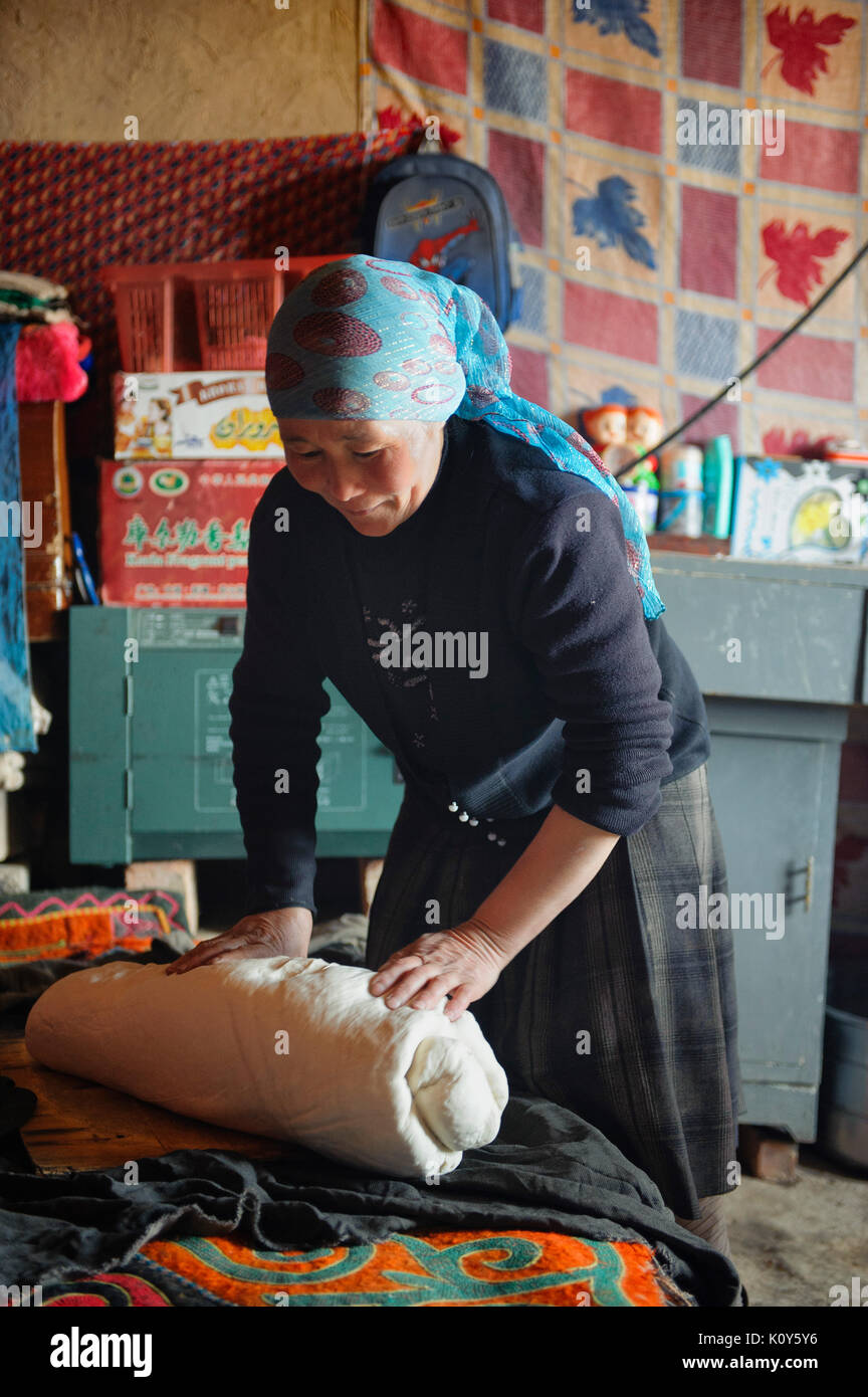 A Uighur woman preparing the dough for the bread. Remote Xinjiang Stock Photo