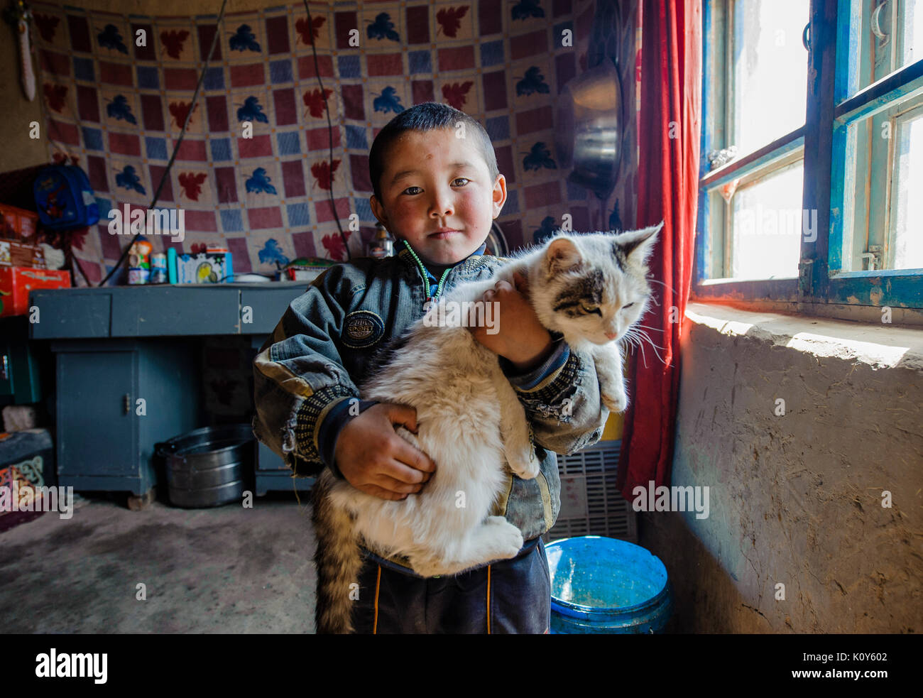 A Uighur kid and his cat. Remote Xinjiang Stock Photo