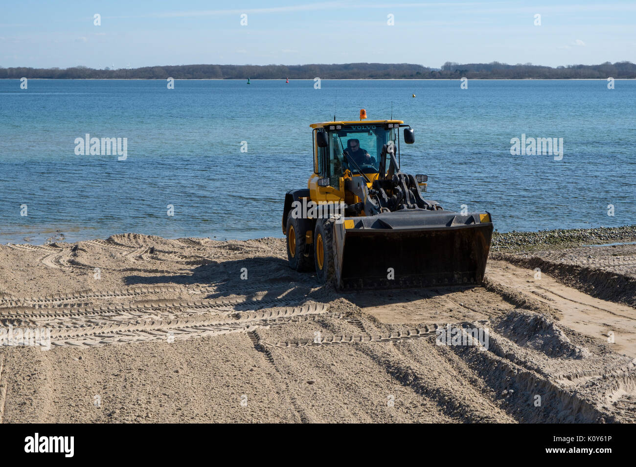 Wheel loader cleans the beach before start of the season, Travemünde, Hansestadt Lübeck, Schleswig-Holstein, Germany Stock Photo