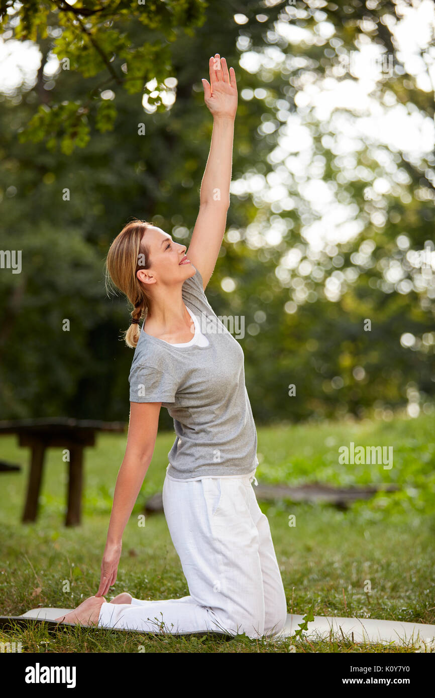 Fit woman doing streching exercises in park Stock Photo