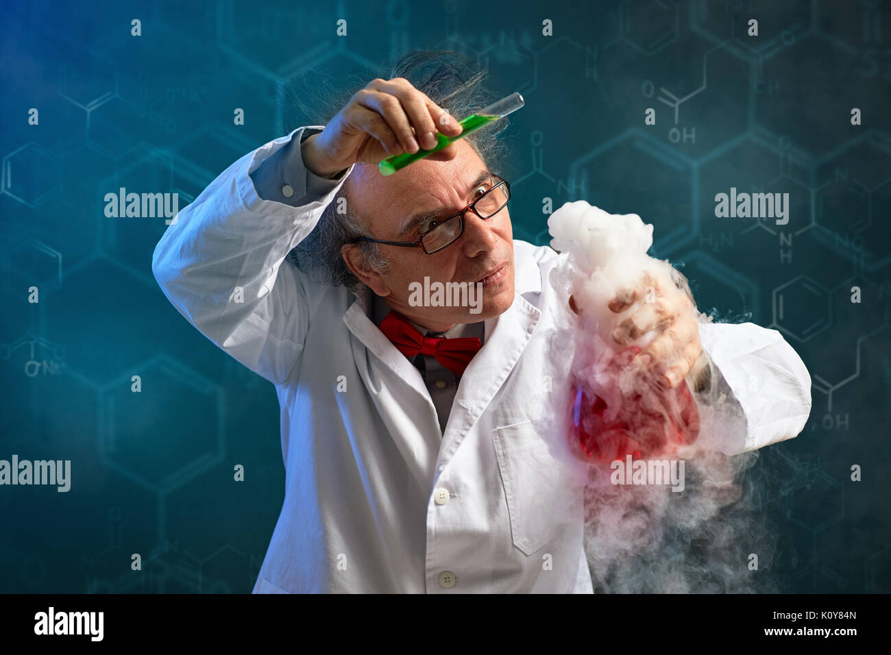 Wacky chemist carefully performed experiment with red toxic chemical and smoke Stock Photo