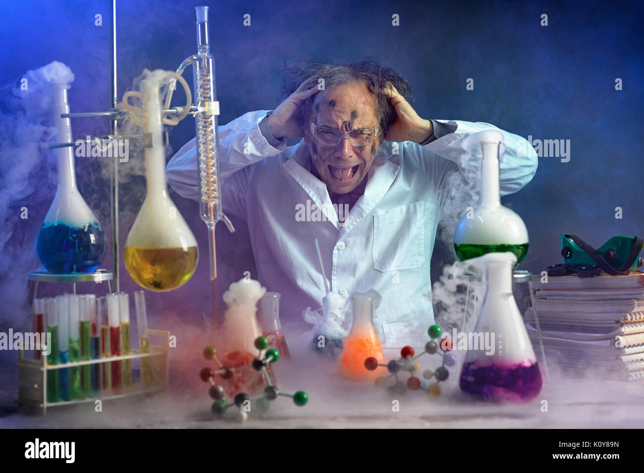 Crazy scientist yelling in his lab front of exploded experiment Stock Photo
