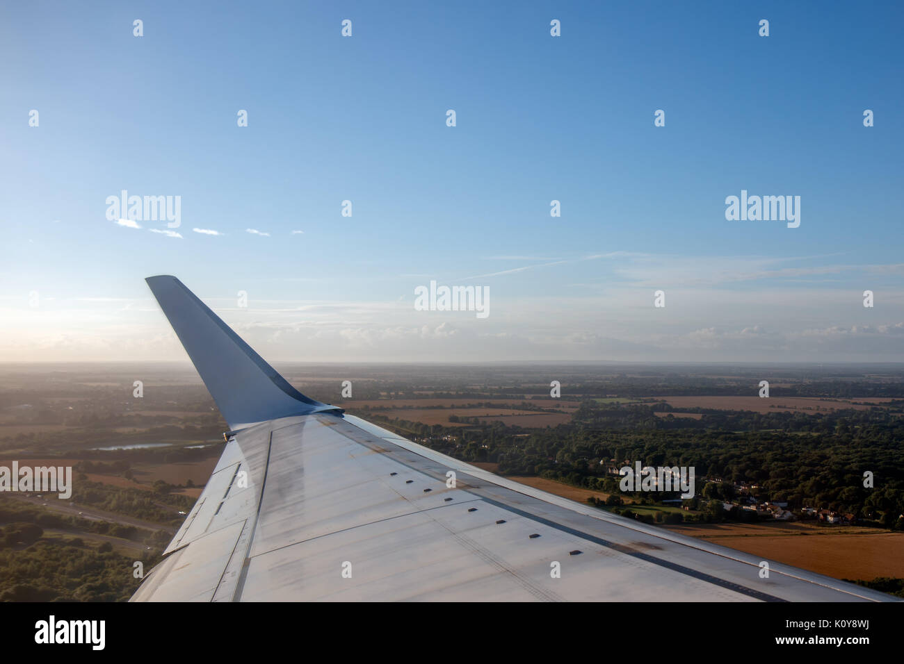 Wing of an airplane flying above the clouds Stock Photo - Alamy