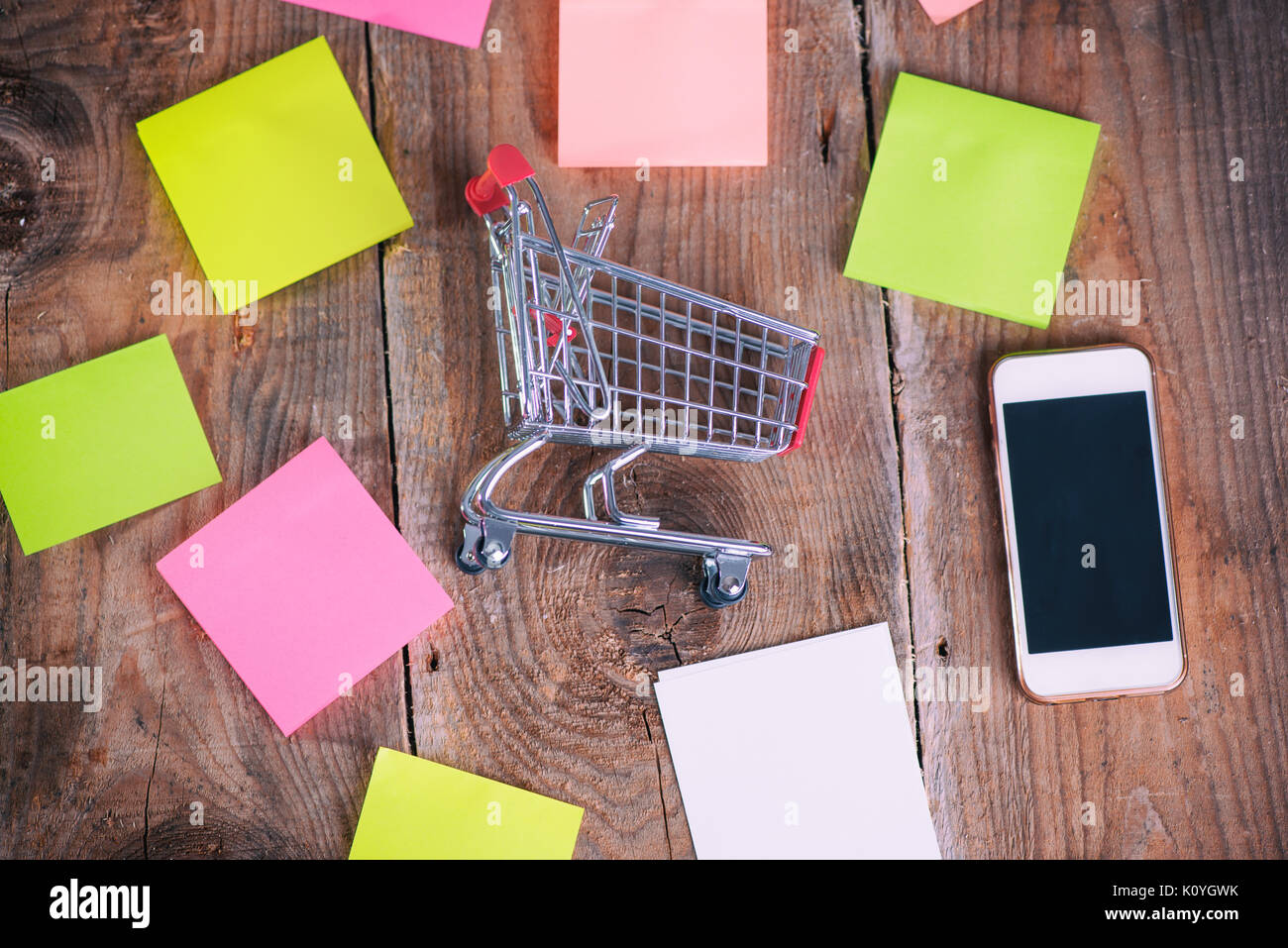 Shopping Cart, mobile phone and paper notes on wooden background Stock ...