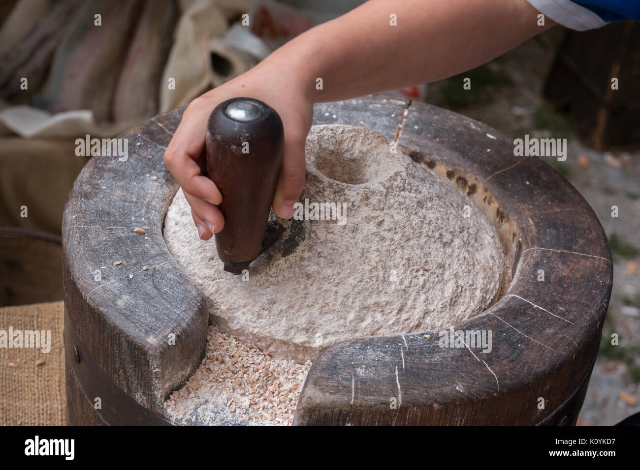 Using an Ancient Manual Stone Mill Stock Photo Alamy