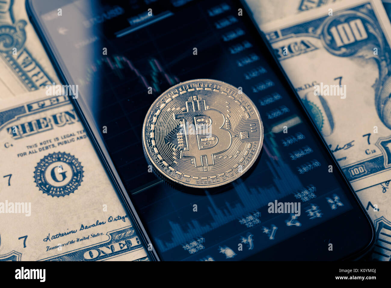 Photo of bitcoin, smartphone with graphics and dollar bills Stock Photo