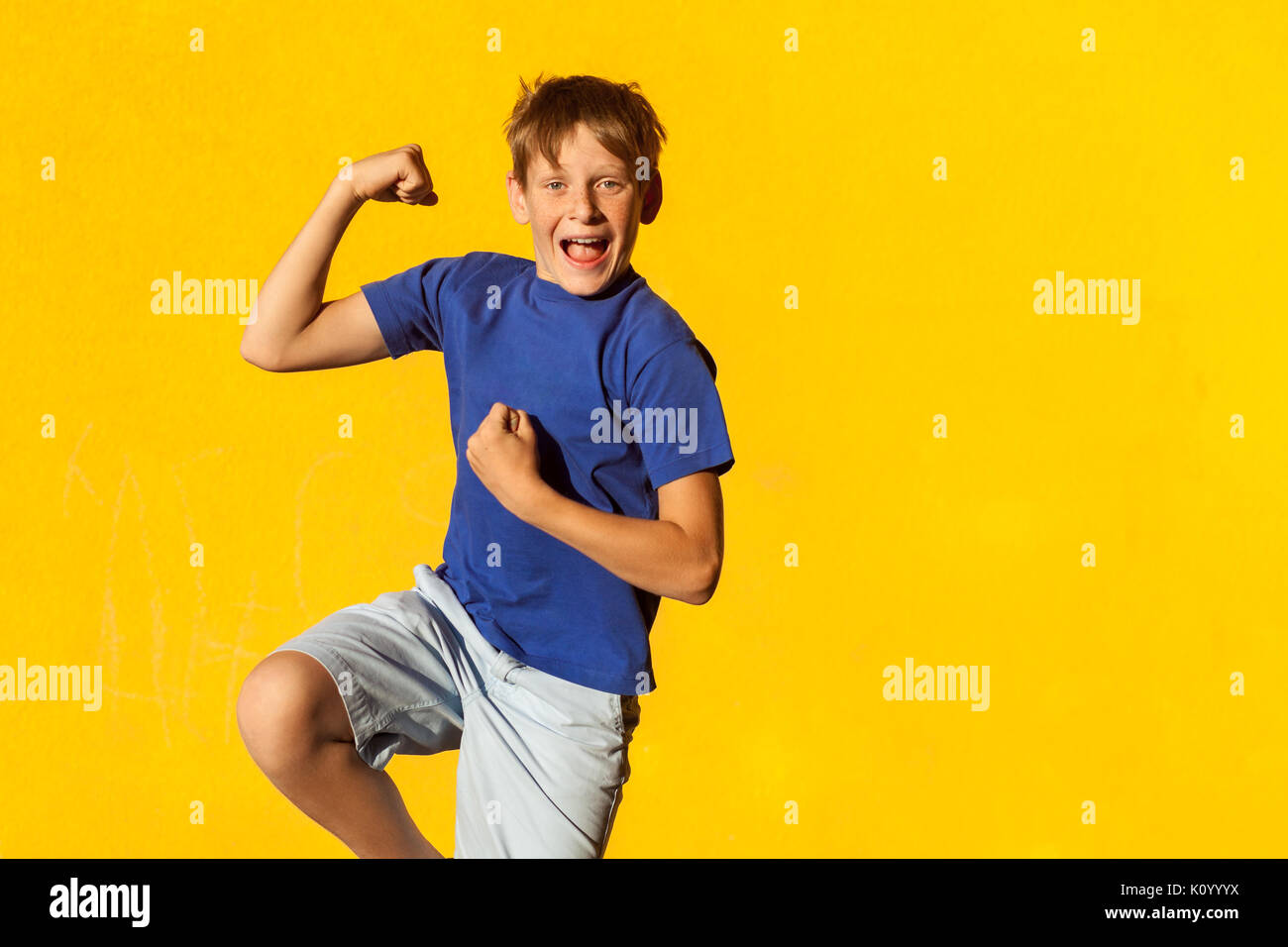 Funny an happiness freckles boy in summer. Indoor, studio shot. Yellow background Stock Photo