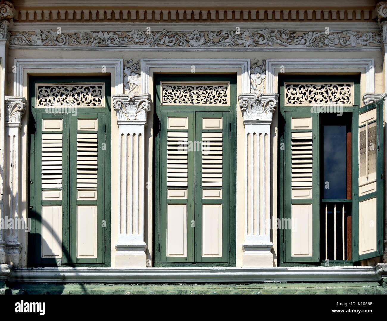 Traditional shop house exterior with green wooden louvered shutters,  windows and ornate ventilation ducts in the Little India District of Singapore Stock Photo