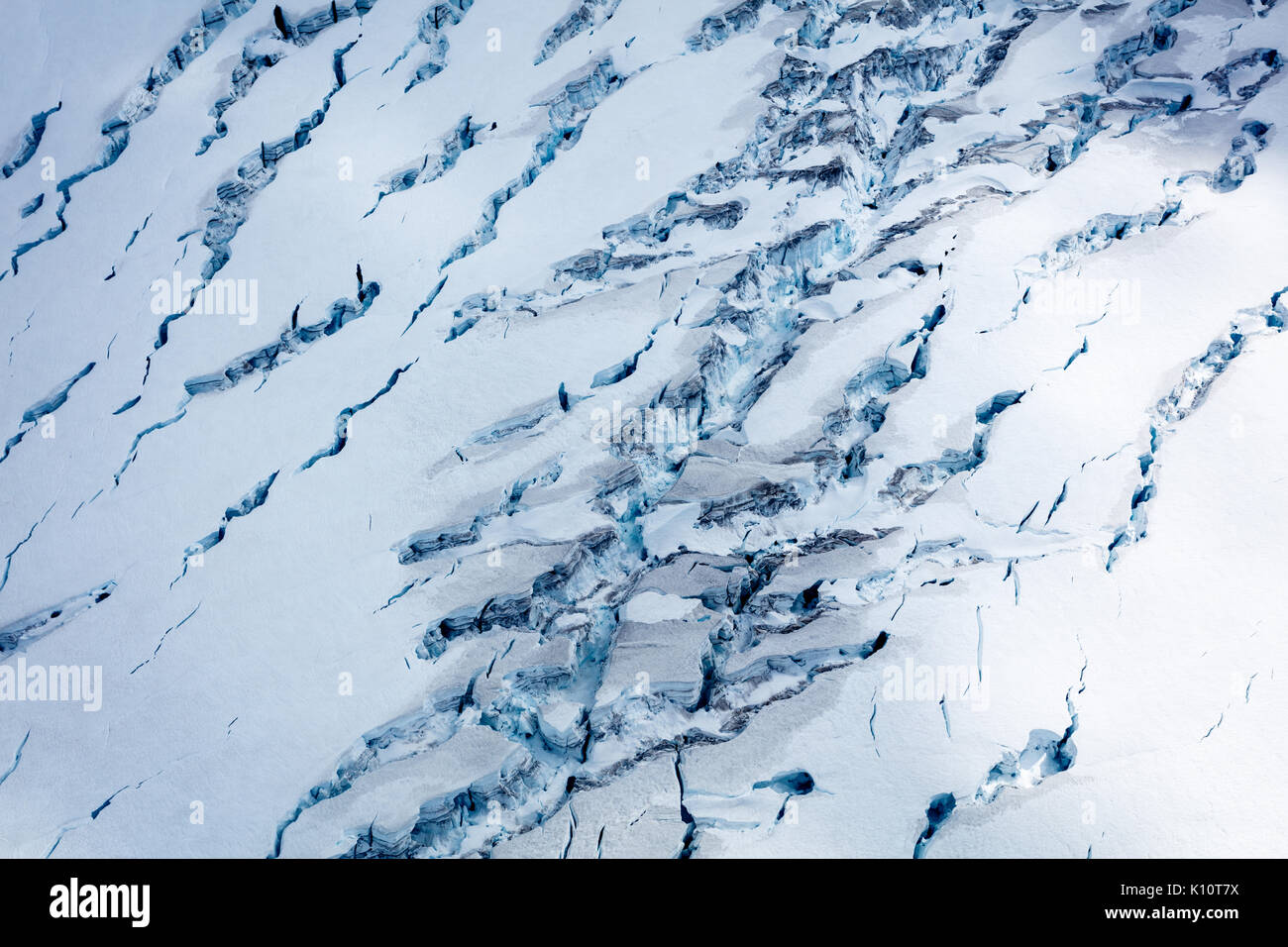 Aerial view of blue pattern of deep glacier ravines atop large active glacier Stock Photo