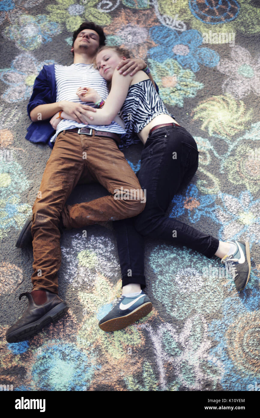 Young couple lies on a painted street Stock Photo