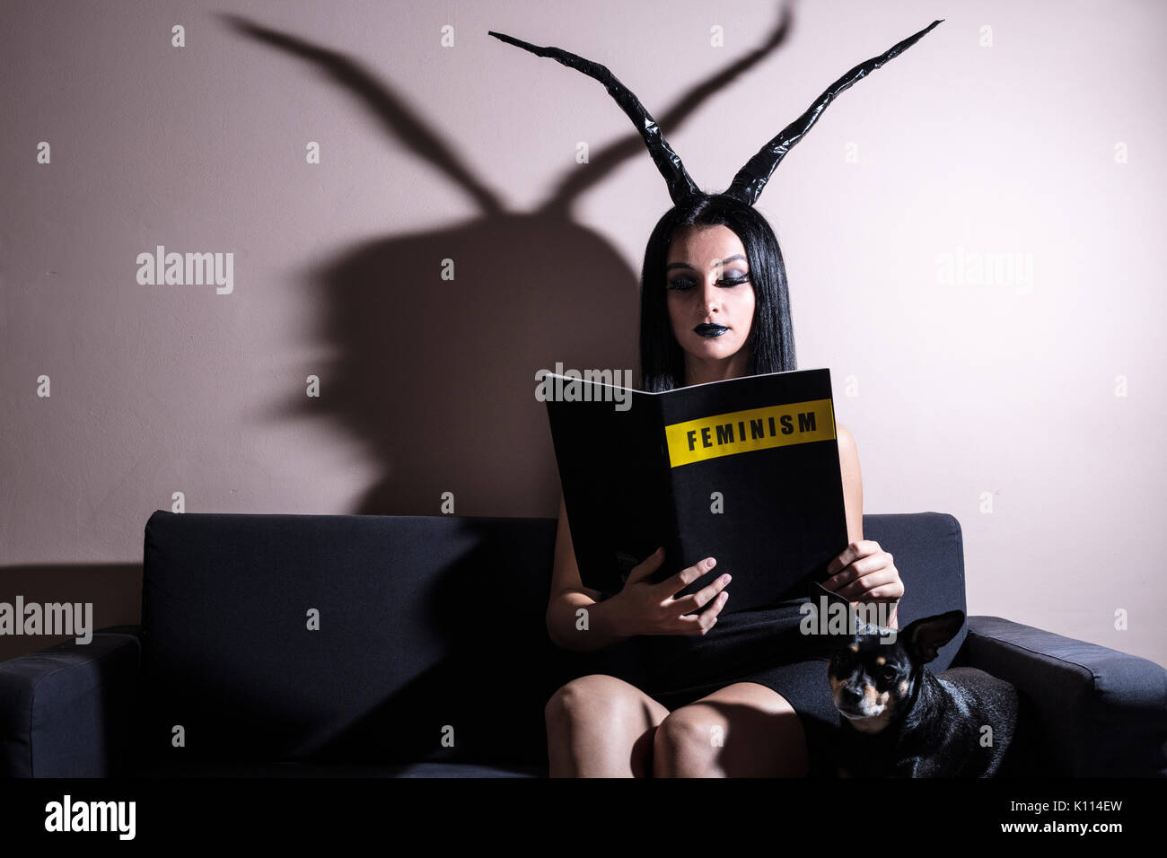 Feminist portrayed as a daemon on a couch Stock Photo