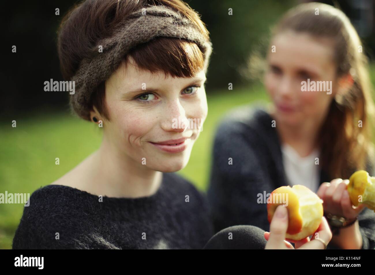 Two young women eating an apple Stock Photo