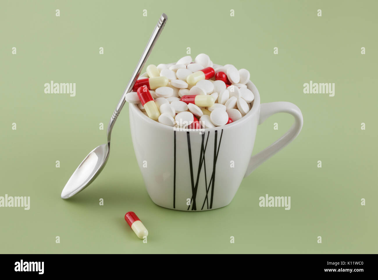 Colored pills in coffee cup Stock Photo