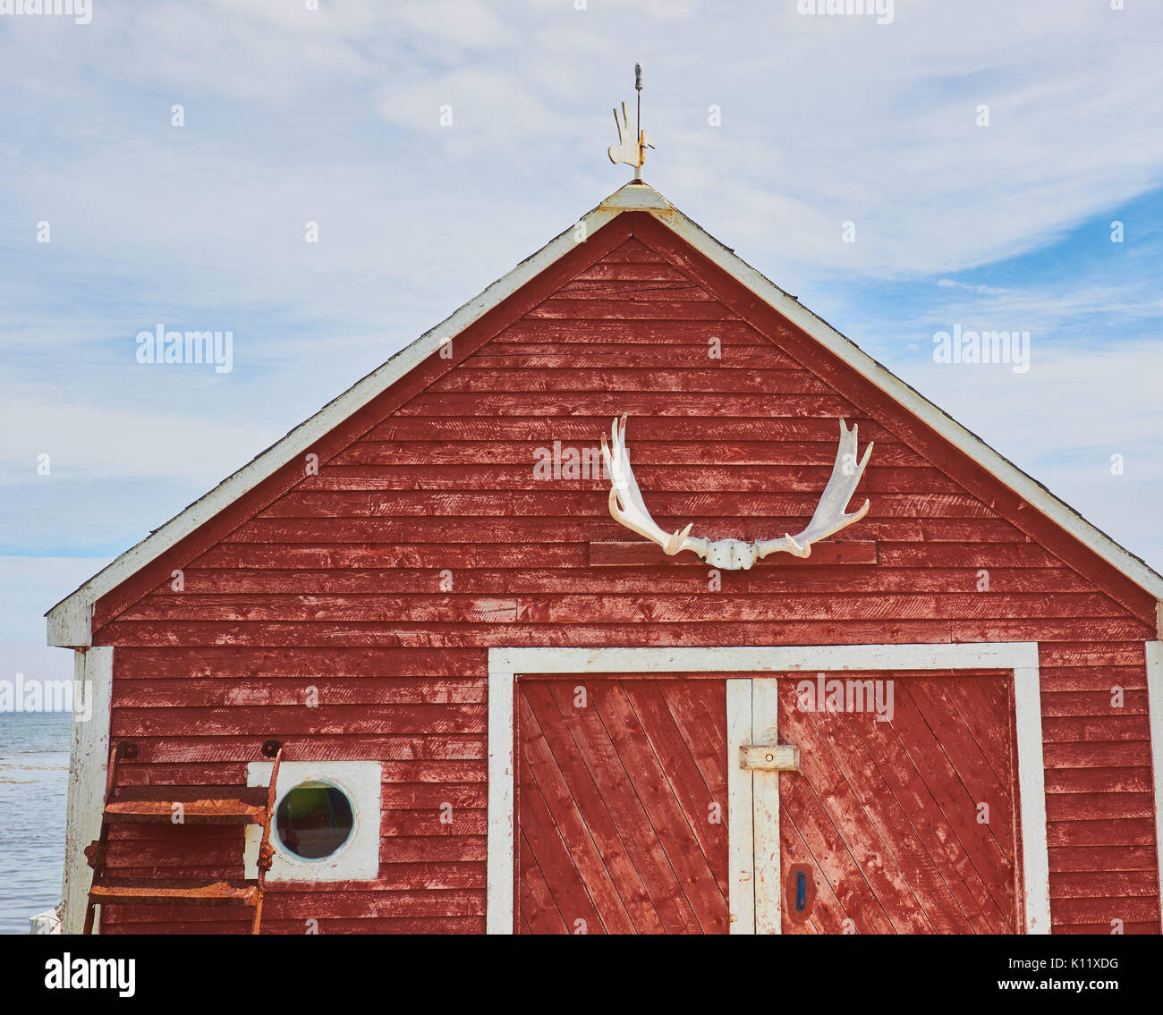 Moose antlers on timber cabin in water's edge community at tip of the Great Northern Peninsula, Newfoundland, Canada Stock Photo