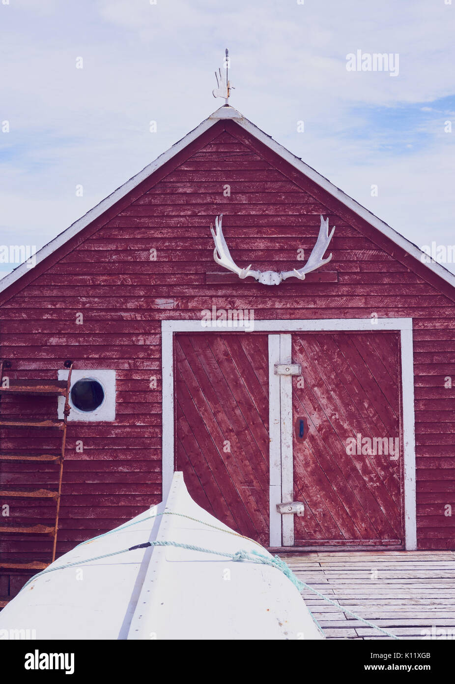 Moose antlers on timber cabin in water's edge community at tip of the Great Northern Peninsula, Newfoundland, Canada Stock Photo