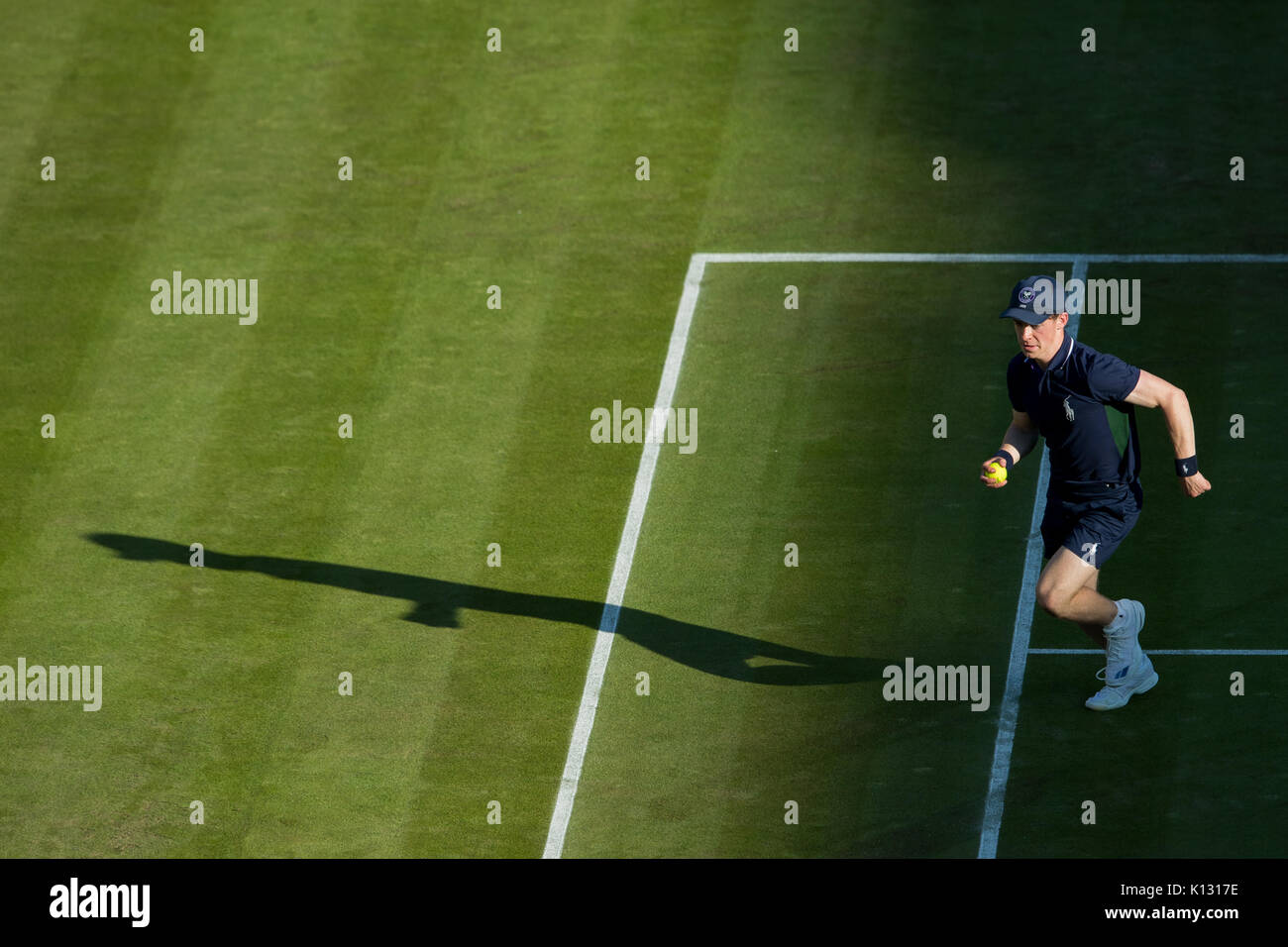 A ball boy running with shadow at the Wimbledon Championships 2017