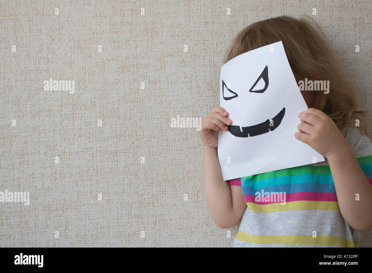 Conceptual portrait. Little child wearing a halloween mask Stock Photo