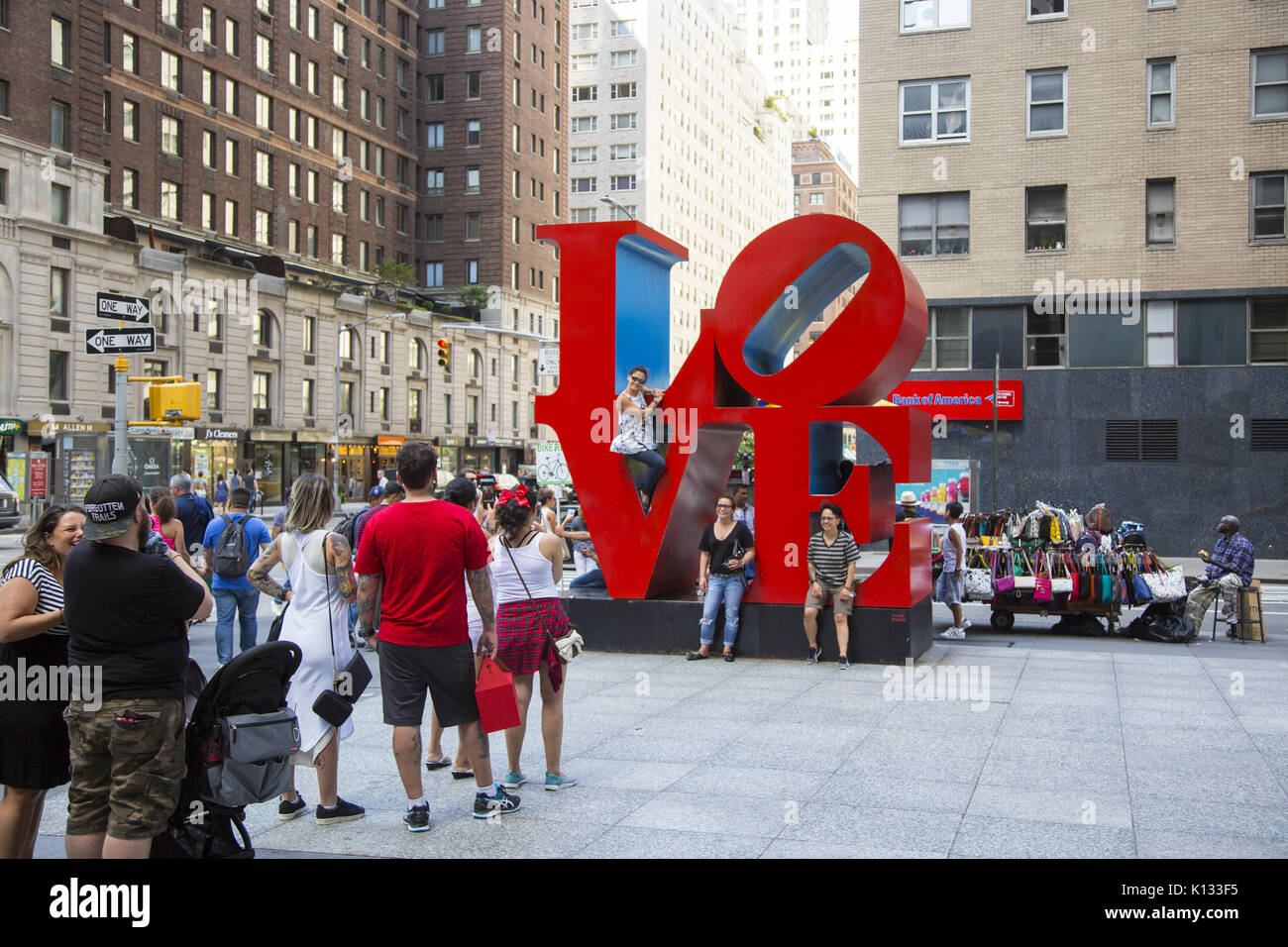 People constantly line up to have their photos taken in front of Robert Indiana's Love Sculpture, a pop art piece, on Sixth Avenue in mid-town Manhattan, which may be the second most popular sculpture in the city (after the Statue of Liberty). Stock Photo