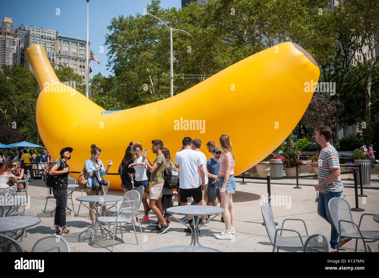 A giant inflatable banana stands in Flatiron Plaza in New York on Sunday, August 20, 2017 as part of the Chiquita 'Banana Sun' branding event. Chiquita has claimed the banana shaped sliver of the sun caused by the eclipse and re-named it the 'Banana Sun', also claiming that they are responsible for the eclipse. The tongue-in-cheek branding event also featured free eclipse watching glasses to passer-by. (© Richard B. Levine) Stock Photo